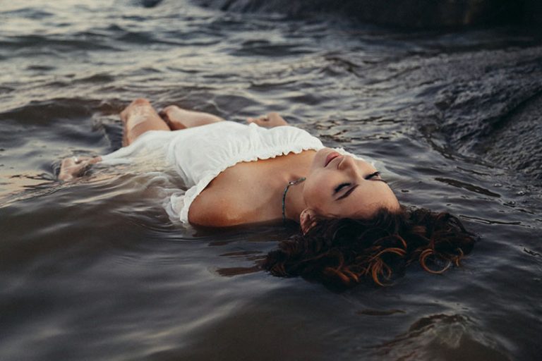 sad woman floating on the water