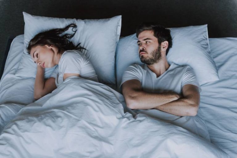 upset man looking at her sleeping girlfriend
