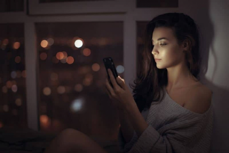 woman sitting and button on the phone
