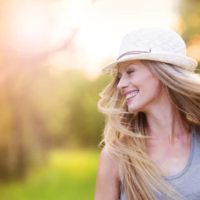 ragazza sorridente che cammina nella natura al tramonto