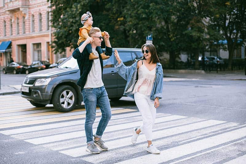 Happy toddler family walking in pedestrian lane