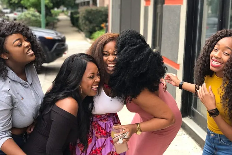 Group of women laughing while on the sidewalk
