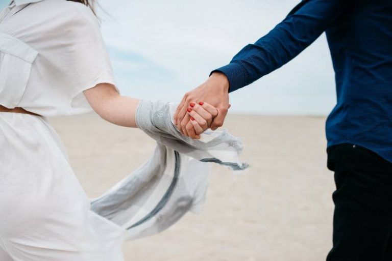 couple holding their hands outside