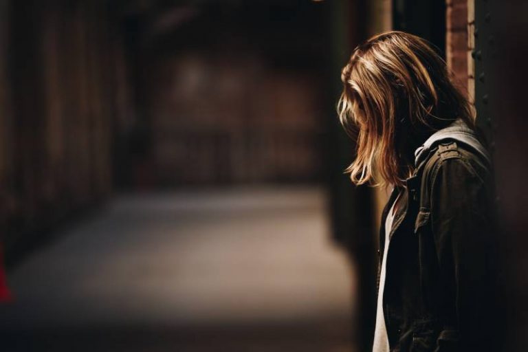 sad girl with heads down in empty building