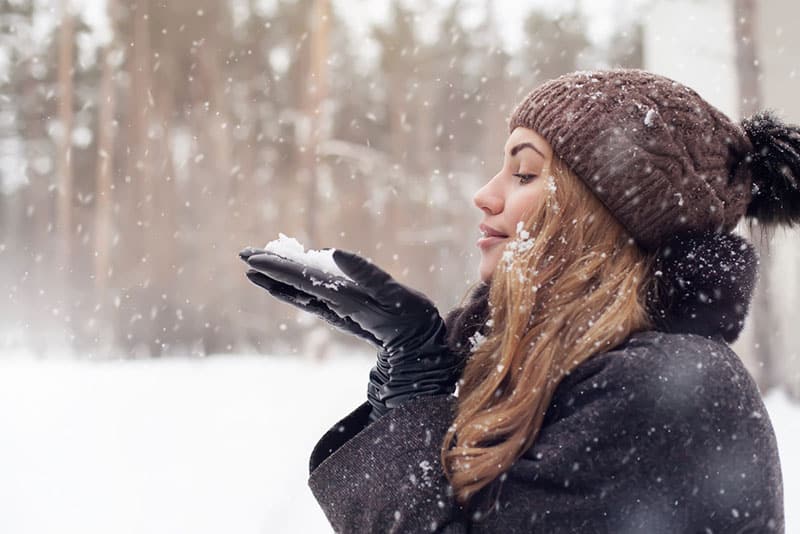 beautiful woman blowing the snow. 