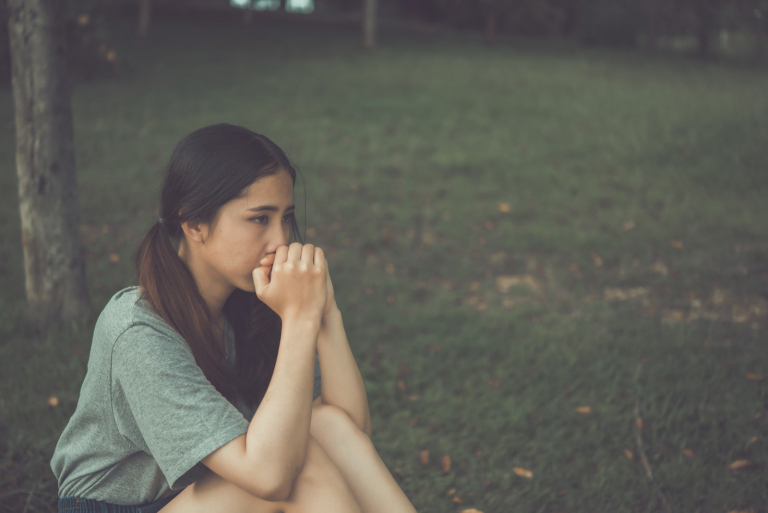 sad woman sitting on the grass