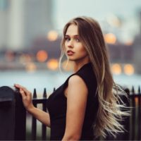 a woman with long brown hair in a black dress