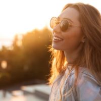 happy young woman smiling at sunset