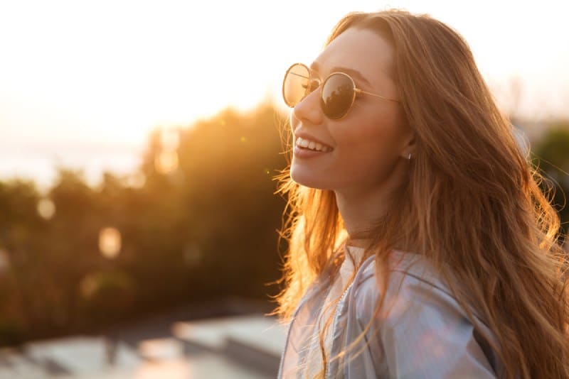 happy young woman smiling at sunset