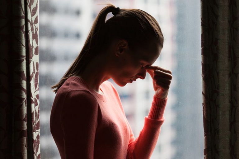 worried woman standing by window