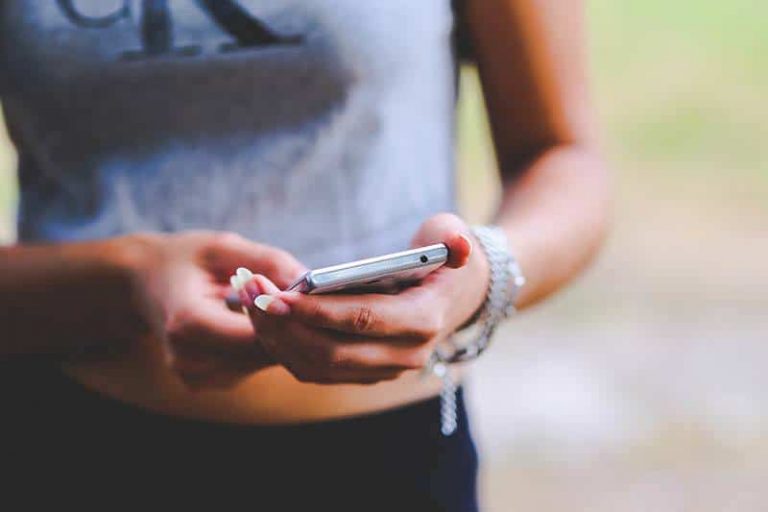 shallow focus of woman typing on her phone