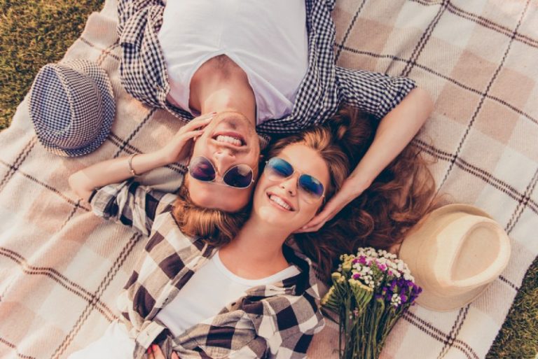 happy couple lying on blanket in nature