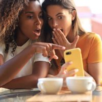 Due amiche che si chiedono qualcosa al telefono