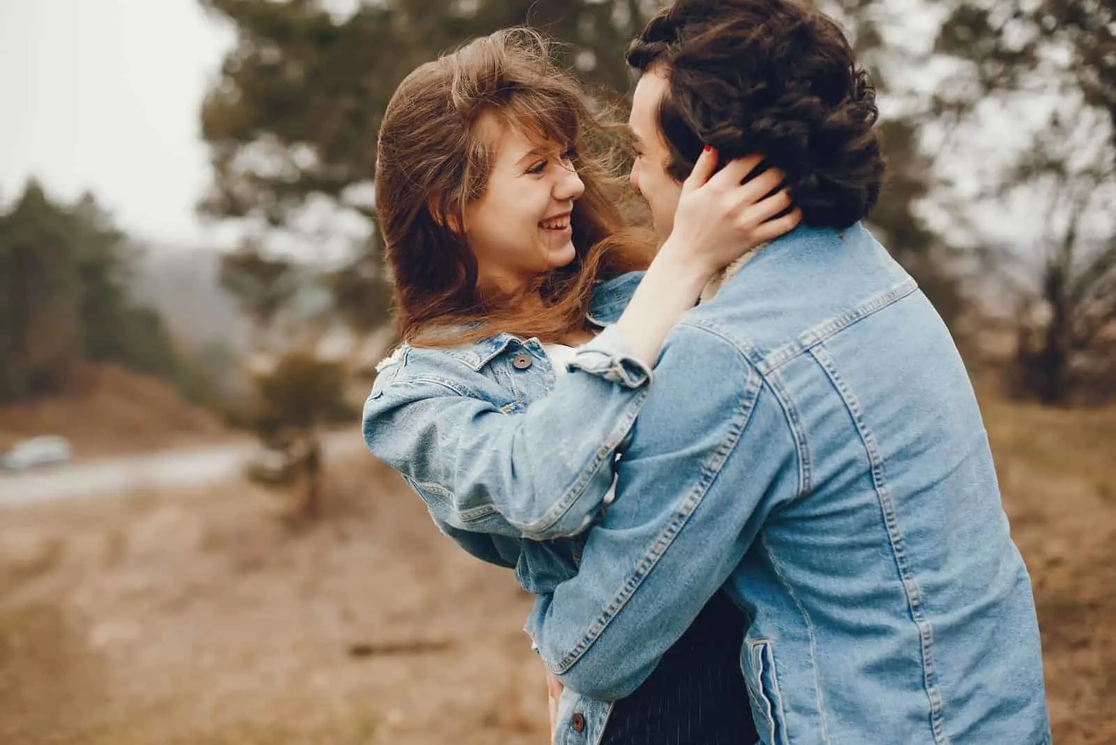 a happy loving couple hugging outside