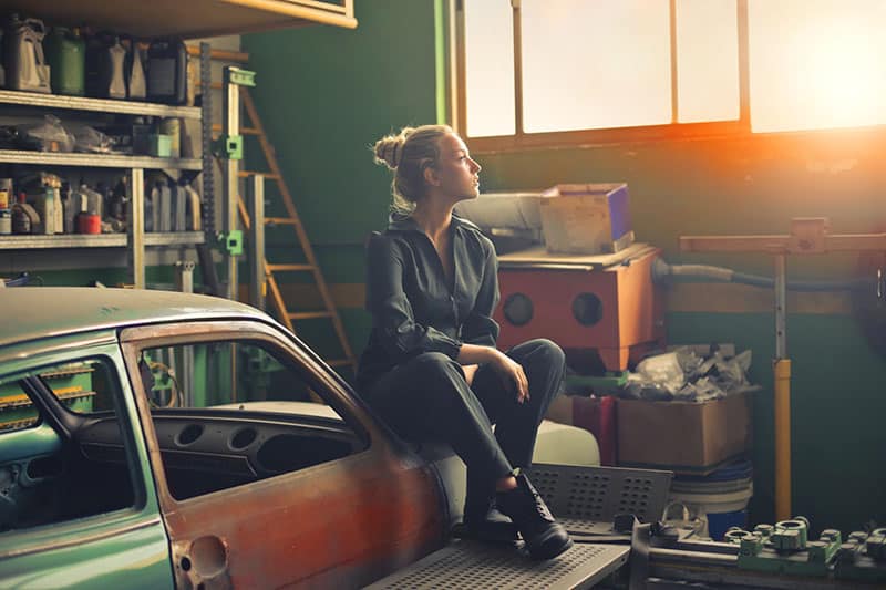 una donna seduta sull'auto in garage