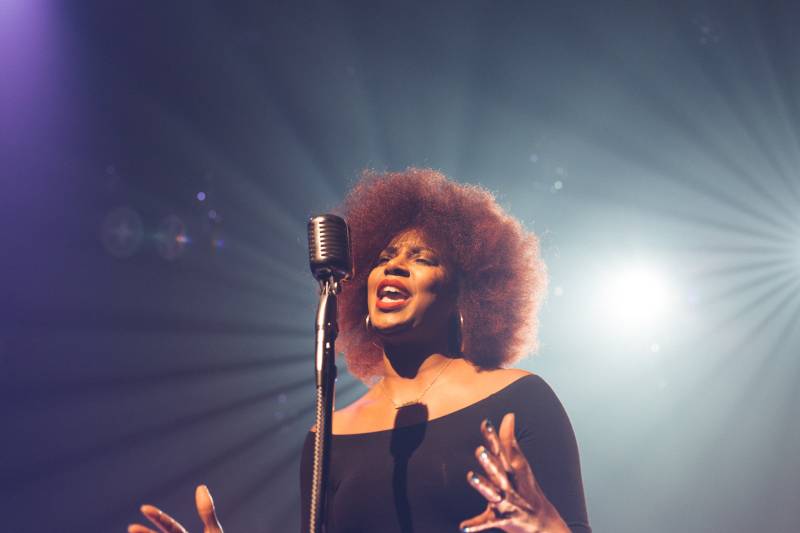 african woman singing on microphone