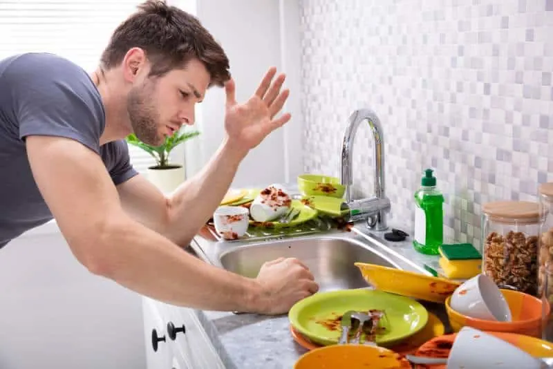 angry man looking at dirty dishes