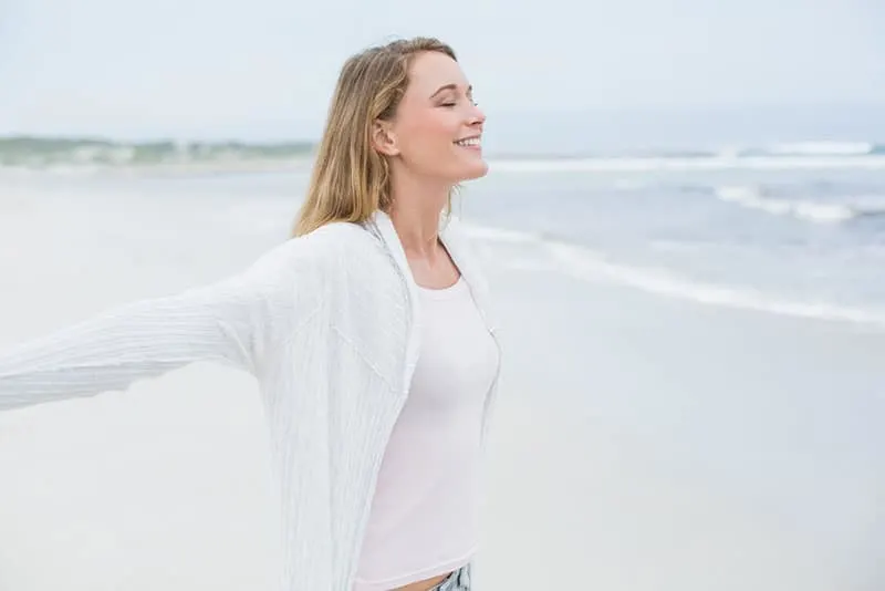 calm woman spreading arms on the beach