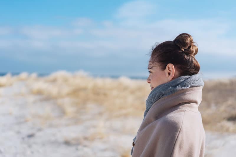 donna tranquilla in piedi sulla spiaggia