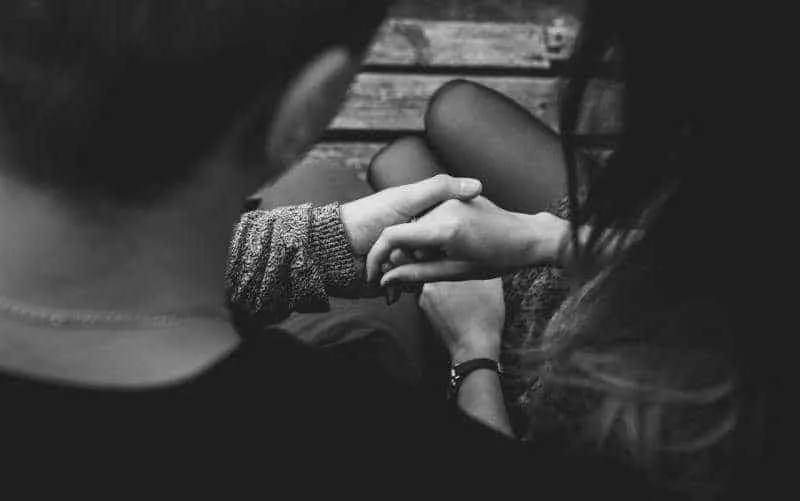 Black and white close up of couple holding hands