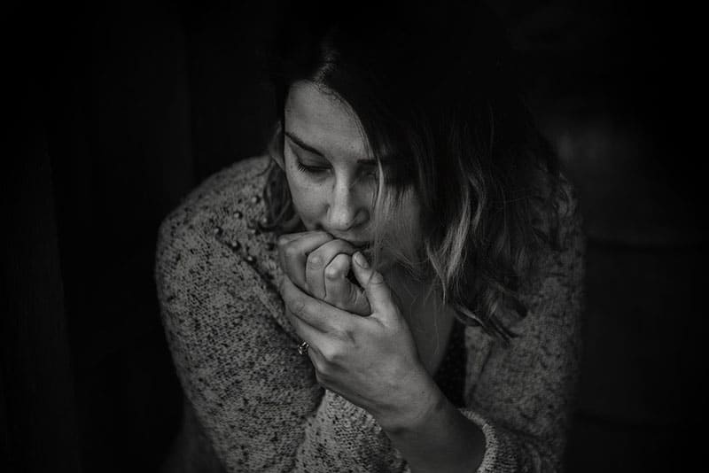 fotografia in scala di grigi di una donna confusa che indossa un top a maniche lunghe