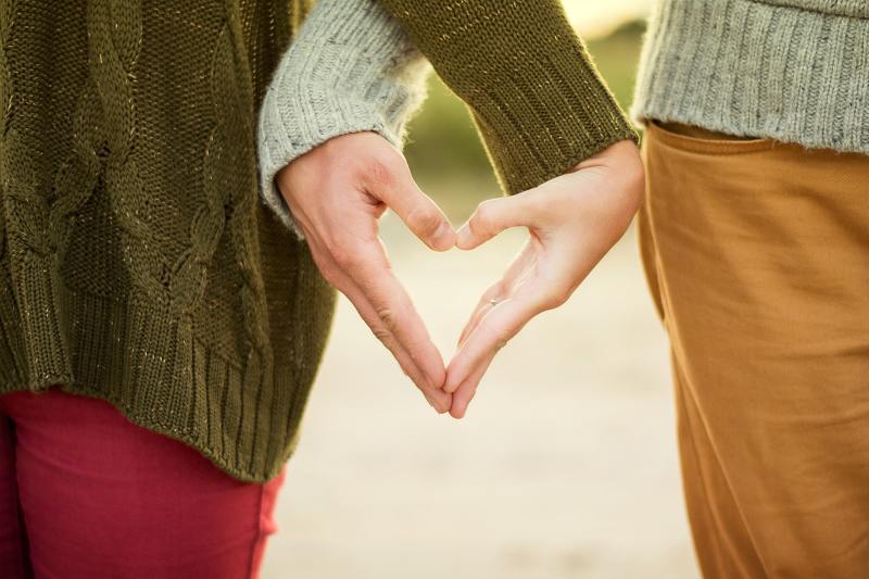 Couple forming a heart with their hands