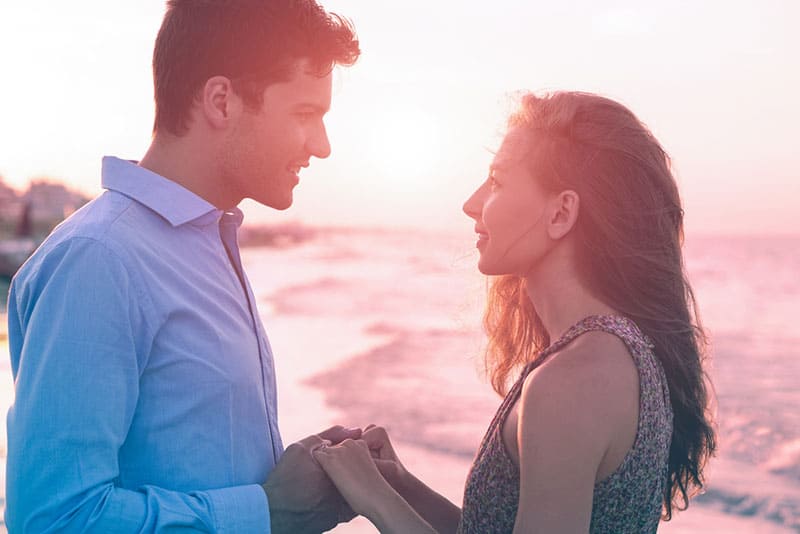 pareja cogida de la mano y mirándose a los ojos