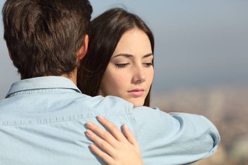 couple hug outside while girlfriend feel woried