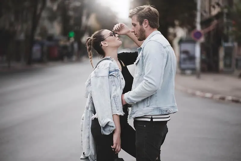 couple in denim facing each other in the middle of the street
