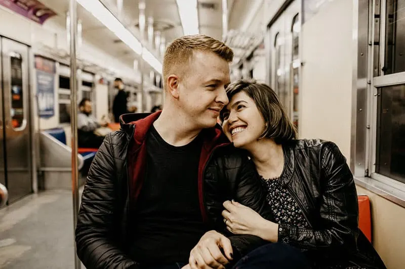 affectionate couple sitting inside a train