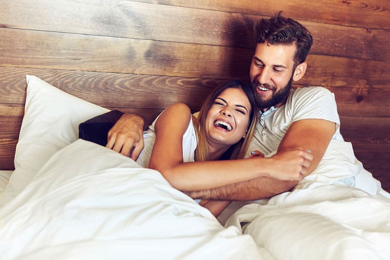 couple laughing in bed