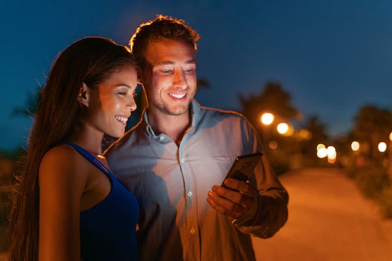 couple looking at phone by night