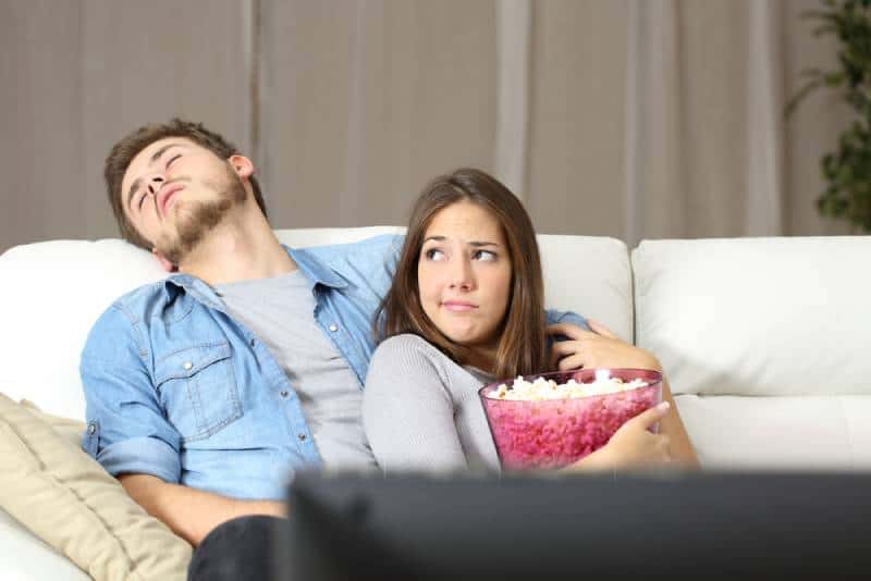 couple watching TV while boyfriend is sleeping
