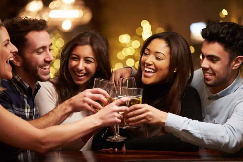 couple with friends cheering at bar