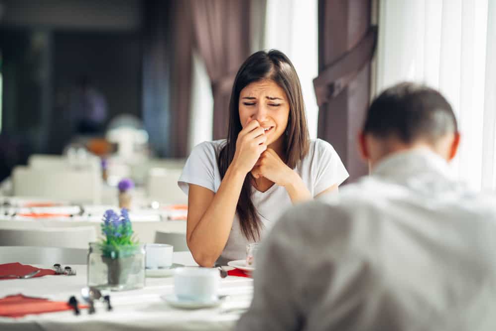 donna stressata in lacrime con il suo fidanzato a tavola