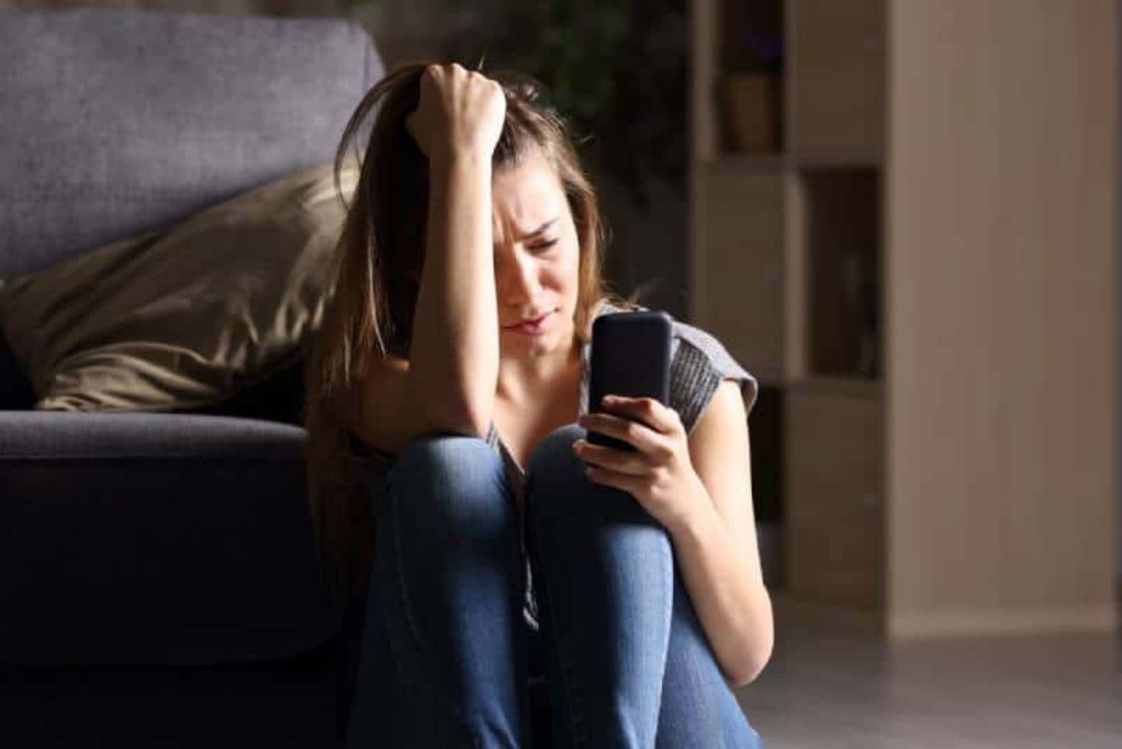 depressed woman looking at her phone