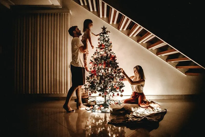 family-decorating-their-christmas-tree under the stairs