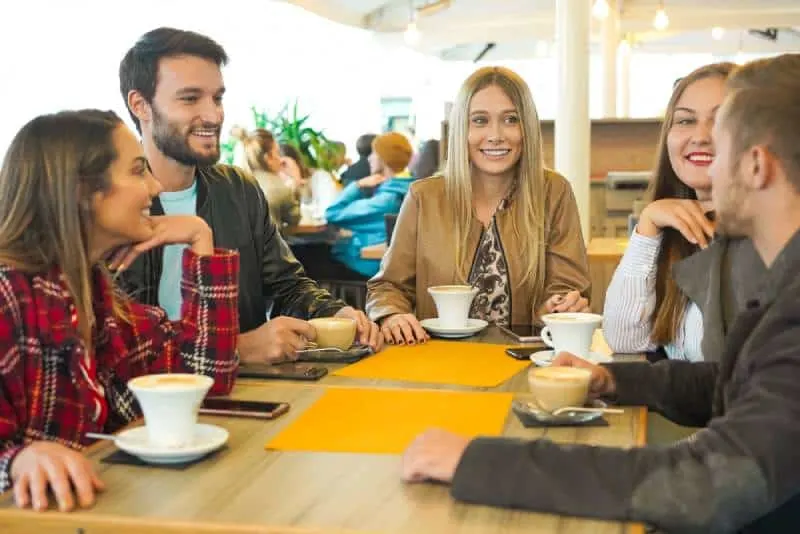 friends at coffe bar having positive conversation