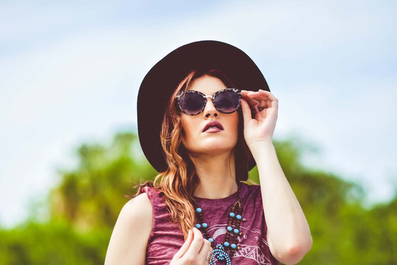 rapariga com óculos de sol e chapéu