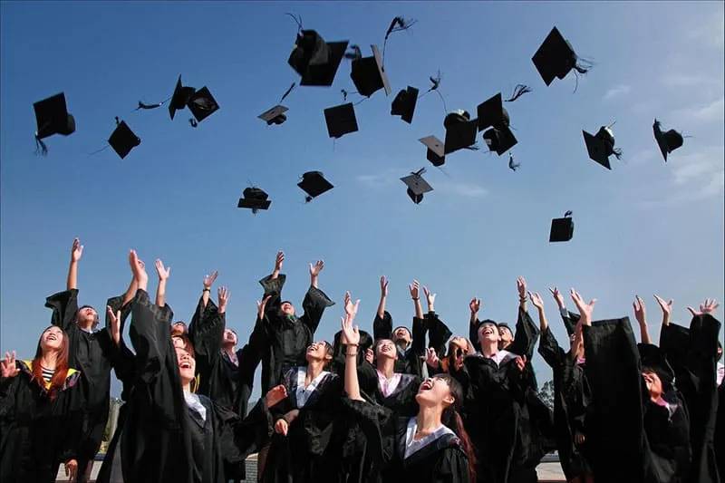 group of graduates throwing graduation caps