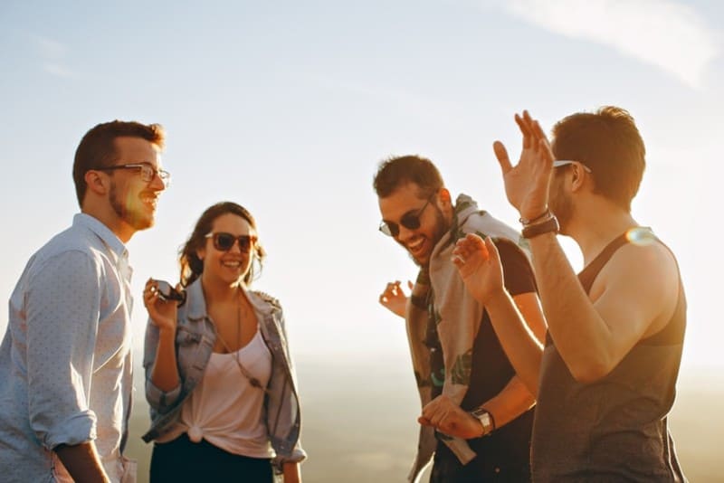 três homens e uma mulher a rir durante o dia