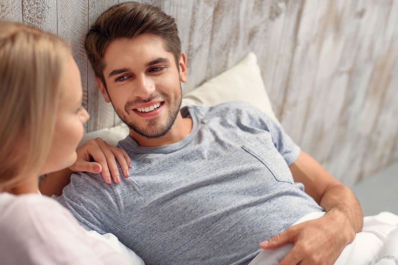 hombre guapo tumbado en la cama con su mujer