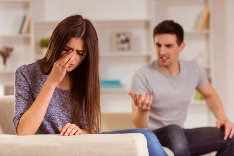 husband yelling at his wife while she is scrying at home
