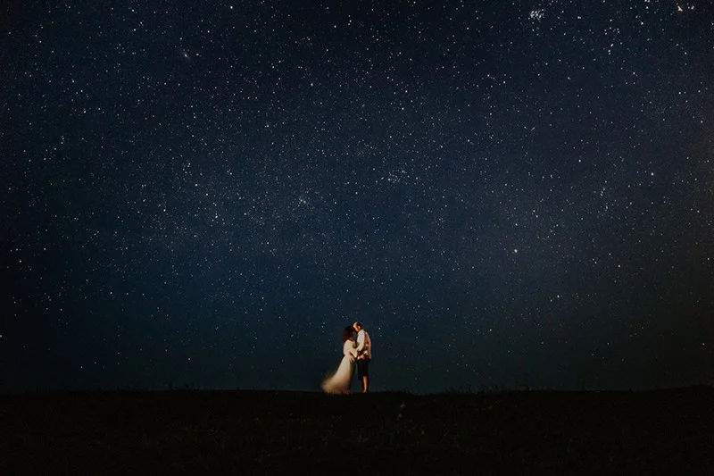 man and woman at night under star sky