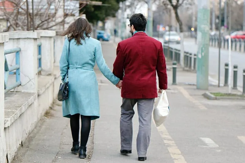 Man and woman walking on sidewalk