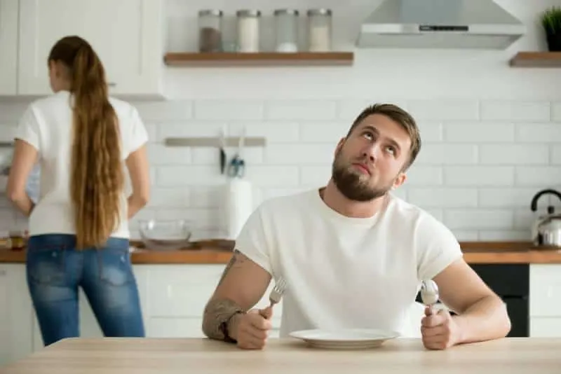 man look bored while waiting for dinner from wife