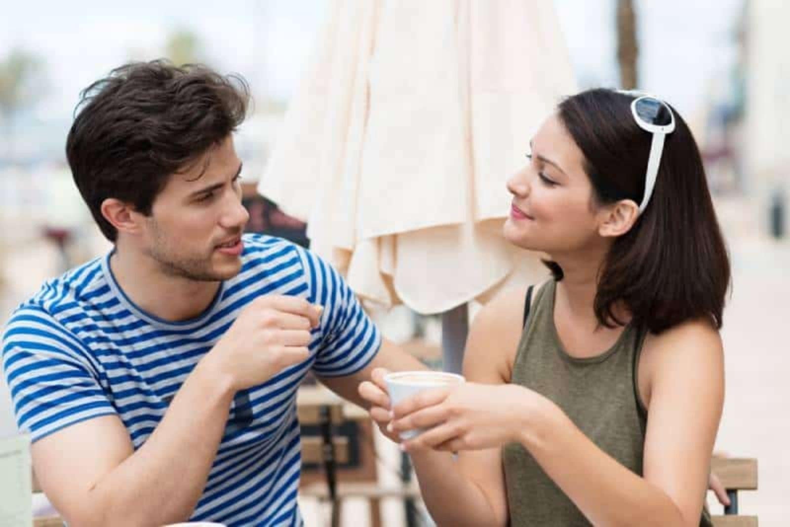 homem a falar com uma mulher num café bar