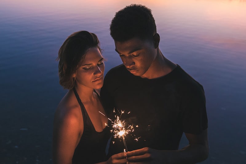 man and woman holding sparklers