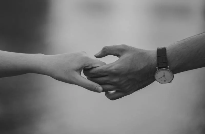 Monochrome photo of couple holding hands