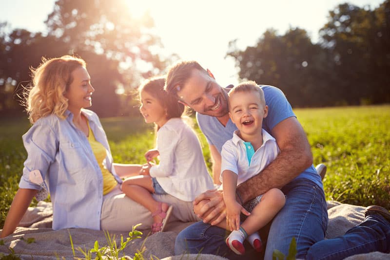 genitori che si divertono con i bambini nel parco